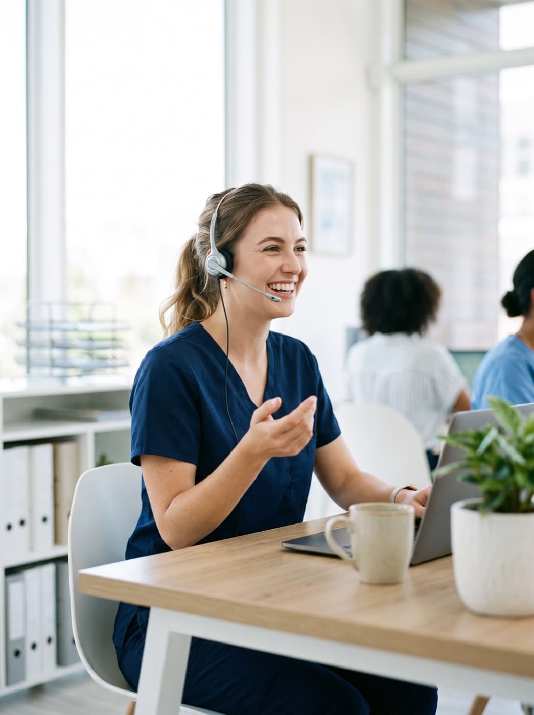A care team member on a headset, smiling as she helps a caller